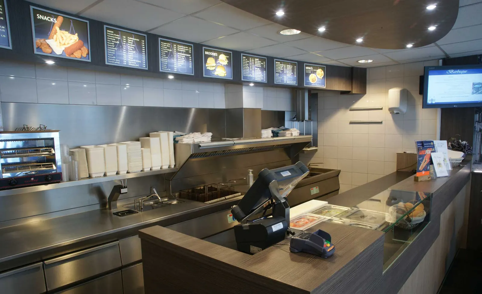 Interieur van Cafetaria de Vesting met balie, keuken en menuborden