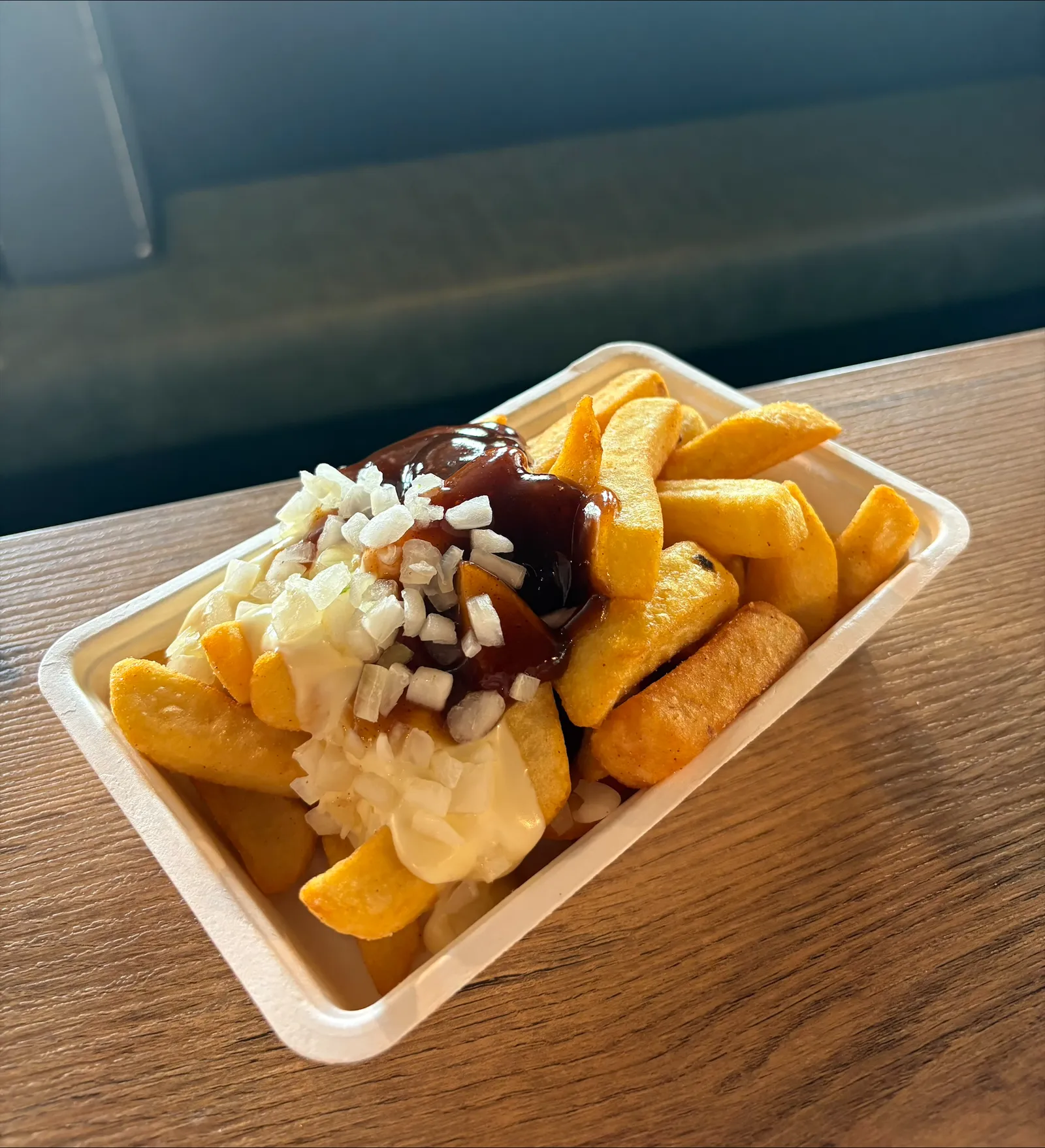 Bakje verse patat met mayonaise, gehakte ui en satésaus