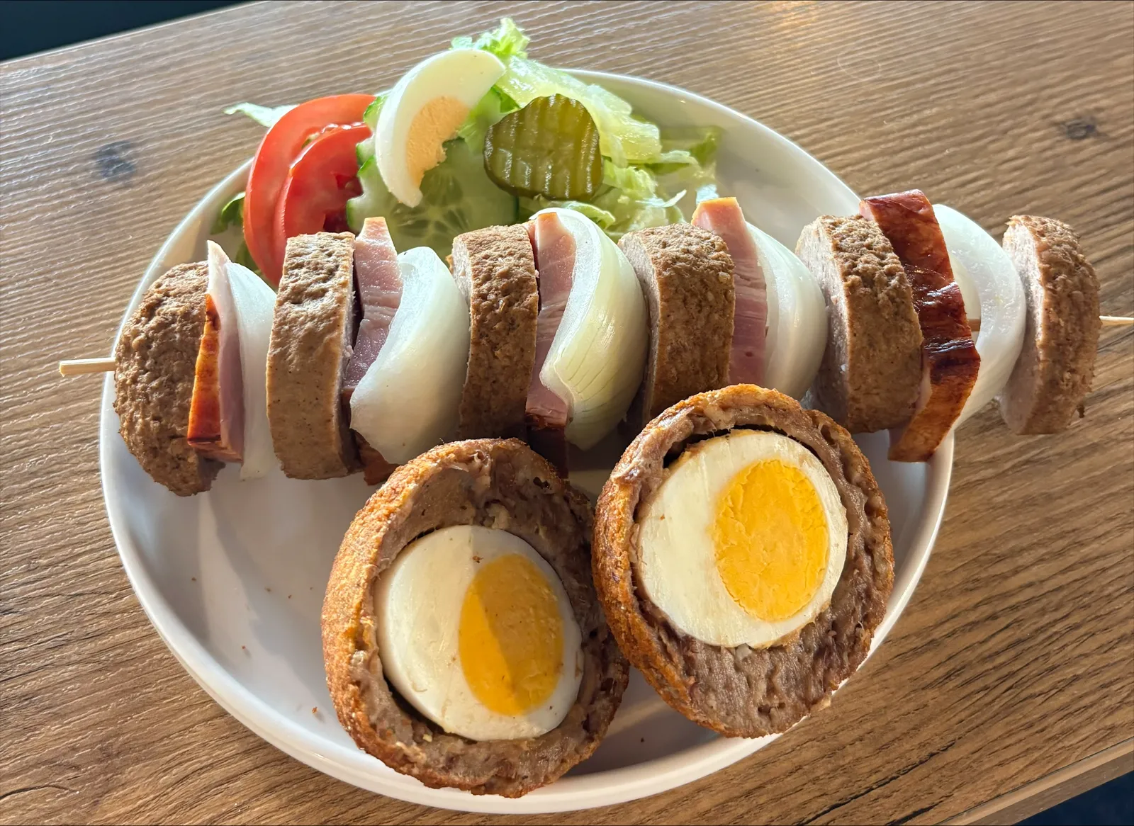 Bord met een snackspies, gehalveerde eierballen en frisse salade