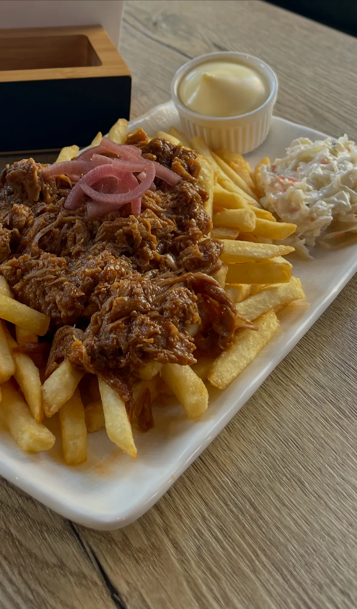 Frites belegd met pulled pork, coleslaw, mayonaise en rode ui